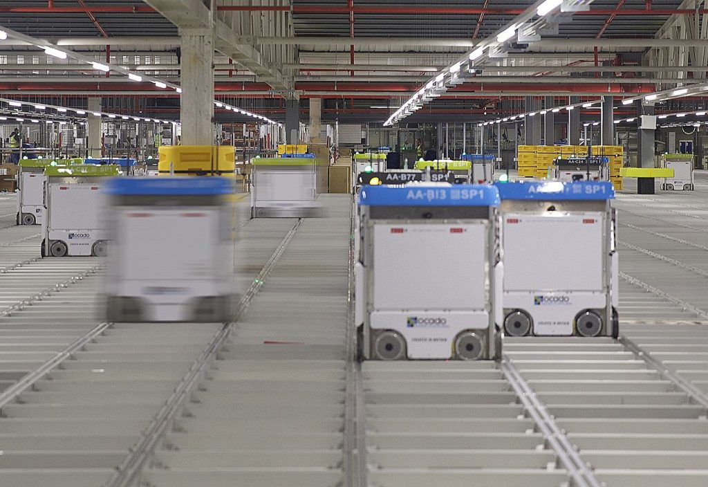 autonomous robots transporting goods inside modern warehouse