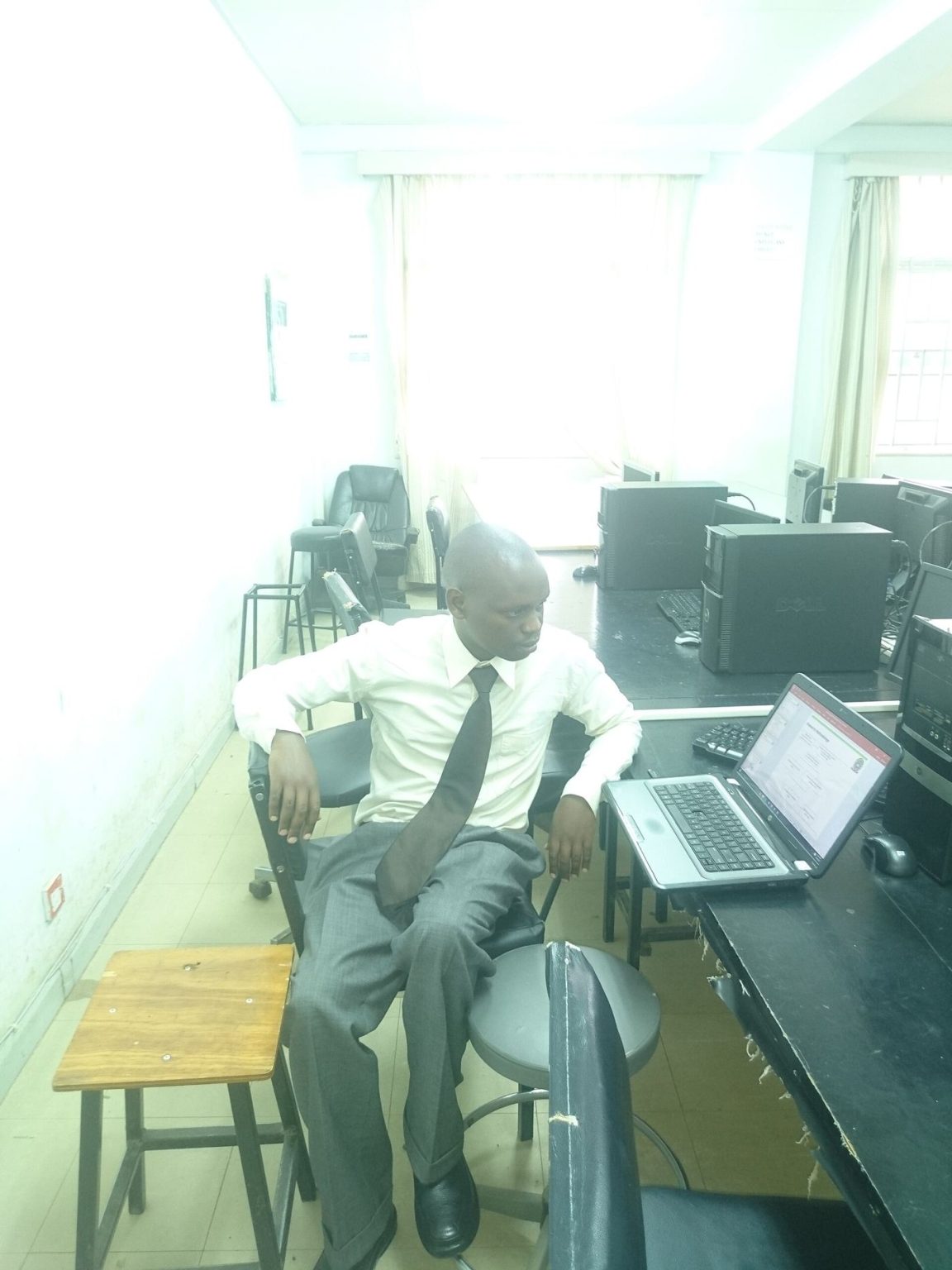 Office workers use laptops at shared desks during a collaborative working day.